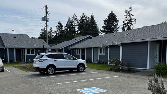 Renovated Pioneer Village residences and accessible parking area in Parksville, BC