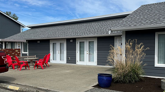 Renovated exterior of Pioneer Village senior housing with resident entrances in Parksville